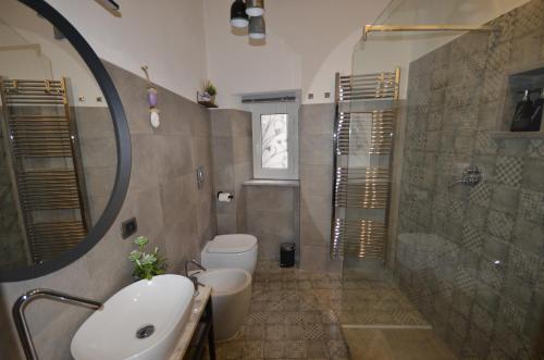 苏特里Goose House Luxury Holiday Home的一间带水槽、卫生间和镜子的浴室