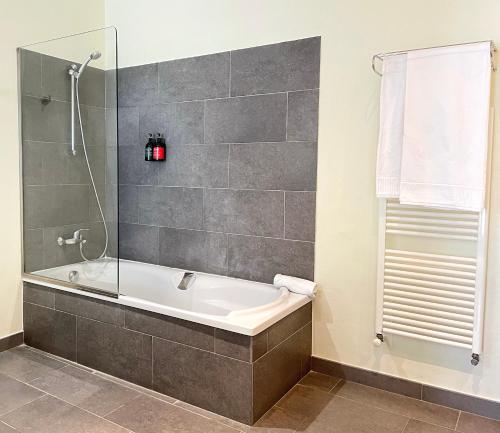 巴利-略夫雷加Hotel Mas del Sol的设有带浴缸和淋浴的浴室。