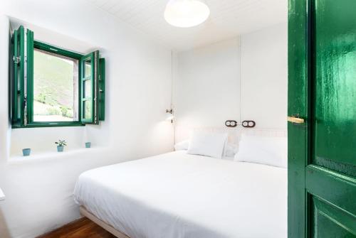 La FocellaTerra Ecoturismo Casa La Casita verde的一间卧室设有一张床和一个绿门