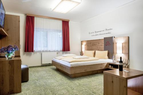 斯拉德明DIE BARBARA Appartements & Zimmer的一间卧室配有大床和红色窗帘