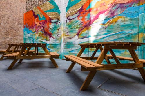 利物浦Duke Street Boutique Hotel的壁画前的两根木凳