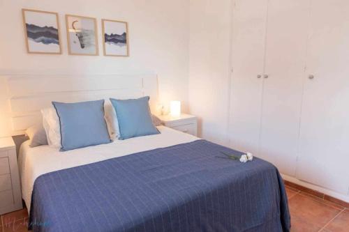 蓬塔翁布里亚Apartamento nuevo junto a la playa vistas al mar的一间卧室配有一张带蓝色枕头的床