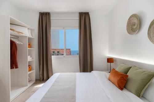 罗列特海岸Apartamentos Venecia的卧室配有白色的床和窗户。