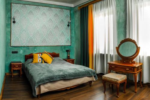 久姆里ARmoon Hotel的一间卧室设有绿色的墙壁和一张带镜子的床