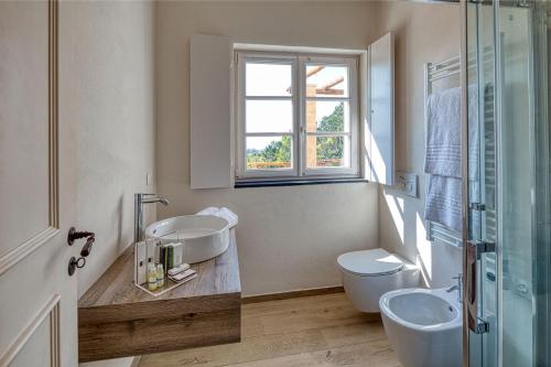 阿伦扎诺Mirandola Suites的一间带两个盥洗盆、卫生间和窗户的浴室