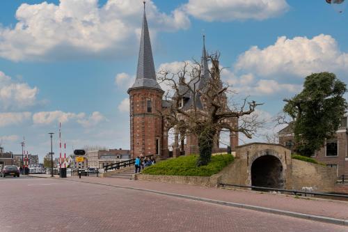 斯内克Stadslogement Hoogend的街上有陡峭的教堂和一棵树