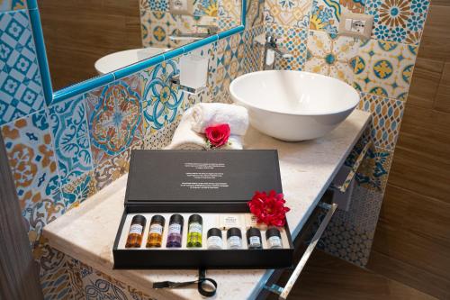 布多尼AQUA SARDINIA boutique hotel的一间带水槽和柜台盒子的浴室