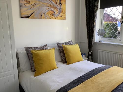 圣奥尔本斯拉吉德厅道住宿加早餐旅馆的一张带黄色枕头的床和墙上的绘画