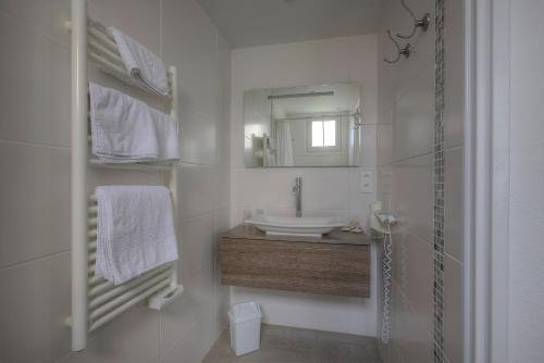 圣特罗让莱班鹦鹉螺酒店的白色的浴室设有水槽和镜子