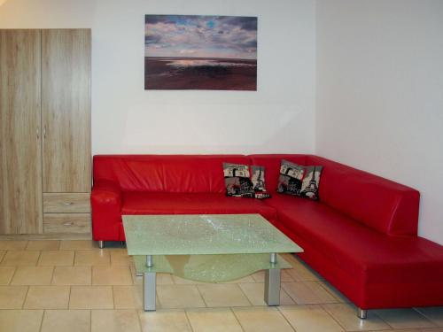 卡尔斯哈根Apartment Gartenstraße-1 by Interhome的客厅里一张红色的沙发,配有桌子