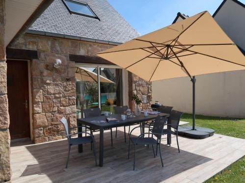 佩罗斯-吉雷克Holiday Home Les Camélias - PGC106 by Interhome的庭院里配有桌椅和遮阳伞