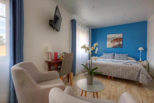 圣特罗让莱班鹦鹉螺酒店的卧室配有一张床和一张桌子及椅子