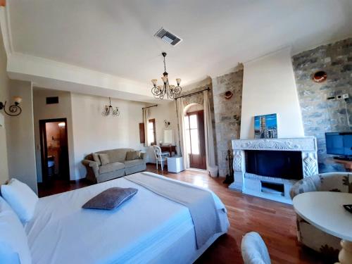 阿里奥波利斯埃里奥珀里斯精品酒店的一间大卧室,配有一张大床和一个壁炉