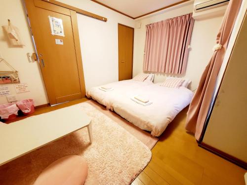 神户Takaraboshi room 301 Sannomiya 10 min的小房间设有床和窗户