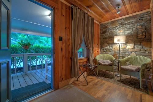 Linville FallsLinville Falls Lodge & Cottages的客厅设有通往阳台的大玻璃门