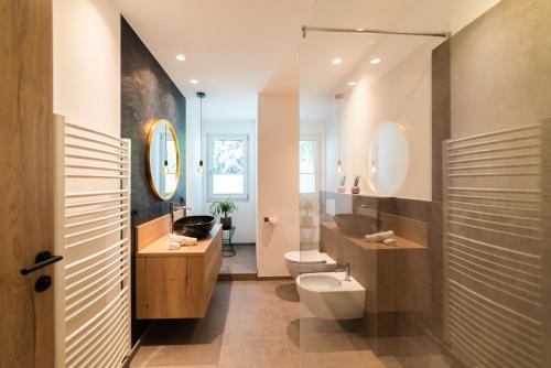 马伦格Marlingsuites的浴室设有卫生间、水槽和镜子。