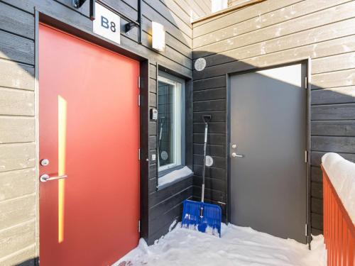 HyrynsalmiHoliday Home Skivillas 61 ukkohalla - b8 by Interhome的建筑物上两扇红色的门,地面上下雪