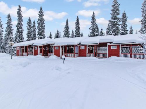 KotilaHoliday Home Lomarivi c4 by Interhome的一座红色的建筑,上面有雪