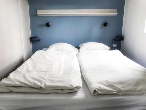 斯欣费尔德Holiday Home De Brenkberg-1的两个白色枕头坐在房间里的床边