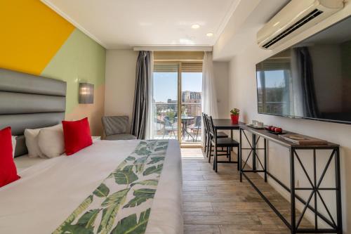 耶路撒冷耶路撒冷帕蒙尼公寓酒店的酒店客房设有一张床、一张书桌和一个阳台。