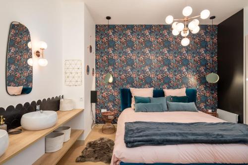 里昂Le Cocon Hygge & SPA的一间卧室配有一张床,墙上装饰着花卉图案的壁纸