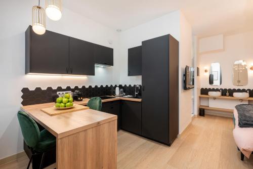 里昂Le Cocon Hygge & SPA的厨房配有黑色橱柜和水果桌