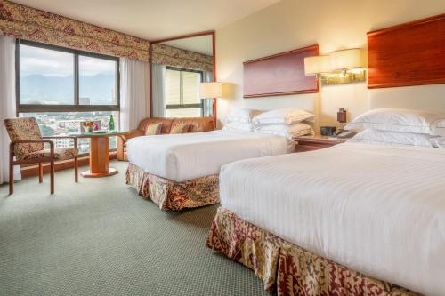 圣何塞圣何塞巴塞罗酒店的酒店客房设有两张床和窗户。