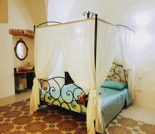 马蒂诺La Casa dei Bombi Nettare & Polline的卧室配有带白色窗帘的天蓬床