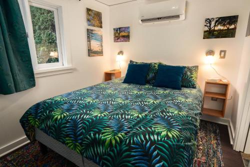 波特兰Secluded Patio Cottage Right By All The Action的一间卧室配有一张带蓝色和绿色毯子的床