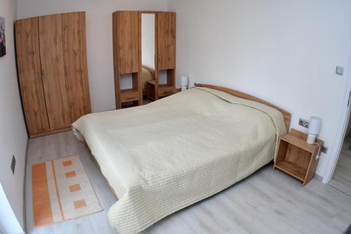 巴拉顿菲兹弗Fűzliget Ezüstnyár的一间卧室配有一张大床和木制橱柜。