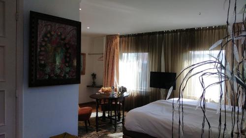 莱茵河畔阿尔芬Rijnzicht的一间卧室配有一张床、一张桌子和一个窗户。