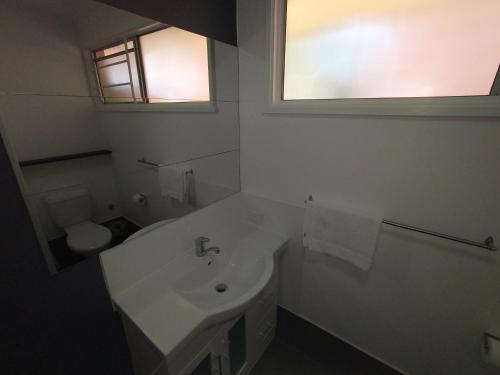 布里斯班阿斯普利日落汽车旅馆的白色的浴室设有水槽和卫生间。