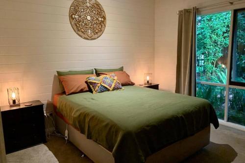 Berrys CreekA Bed & A Red @ Berry’s Creek的一间卧室配有带2个床头柜和1扇窗户的床