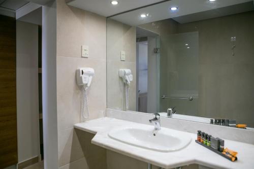 考特索纳里Almyra Hotel & Village的一间带水槽的浴室和墙上的一部电话
