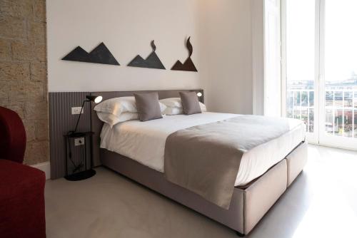 那不勒斯Ciao Bellini的一间卧室设有一张大床和一个大窗户