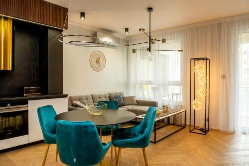 卢布林Apartament Gold - Racławickie 28a的客厅配有桌子和蓝色椅子