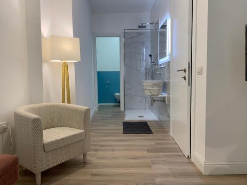 卡利亚里Sa Conca holiday的一间带椅子的客厅和一间浴室
