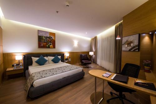 贾姆讷格尔The Fern Residency, Jamnagar的配有一张床和一张书桌的酒店客房