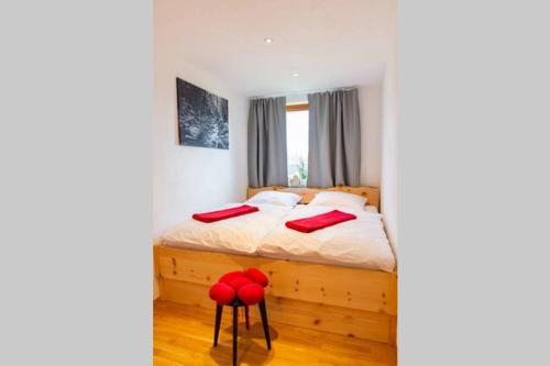 圣玛尔根Appartement Bergsonne的一间卧室配有红色枕头的床