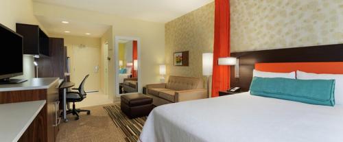 安德森Home2 Suites by Hilton Anderson Downtown的配有一张床和一张书桌的酒店客房