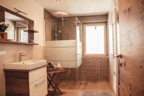 迈斯霍芬Appartement Pointschneiderhof的一间带水槽和玻璃淋浴的浴室