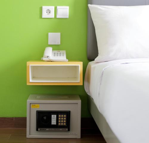 雅加达阿马里斯坦林市酒店的一间卧室配有一张床,床边配有电话