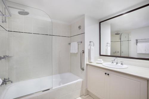 凯恩斯曼特拉滨海酒店的白色的浴室设有浴缸和水槽。