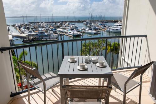 赫维湾曼特拉合维湾酒店的一个带码头的阳台,配有桌椅