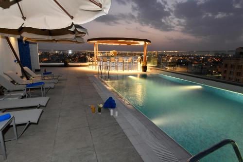 利雅德Golden Tulip Riyadh的建筑物屋顶上的游泳池