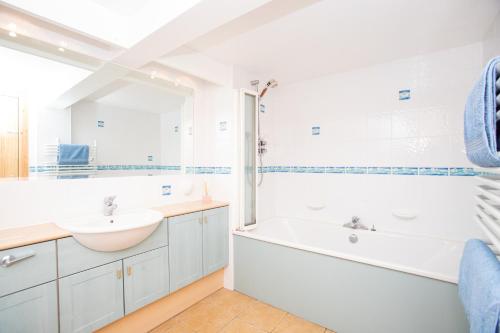 皮特洛赫里Aftonbank的白色的浴室设有浴缸和水槽。