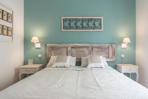 维罗纳Riva San Zeno - Mood Apartments的卧室配有一张带两张桌子的大型白色床