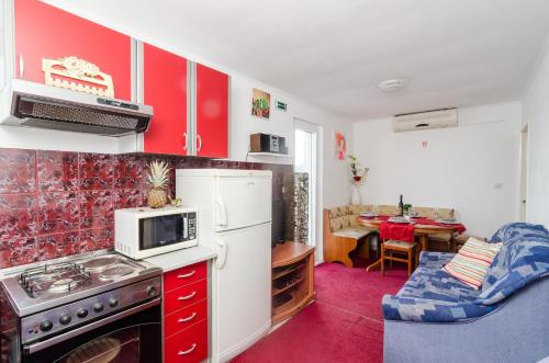 斯拉诺Apartment Giovani的厨房配有红色橱柜和白色冰箱