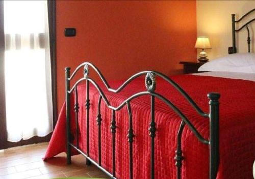 圣伊西多罗B&B Il Casolare的一间卧室配有红色的床和红色毯子