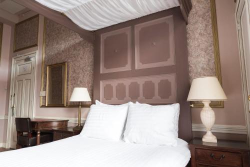 兹沃勒Hotel Fidder - Patrick's Whisky Bar的一间卧室配有一张带两盏灯的大型白色床。